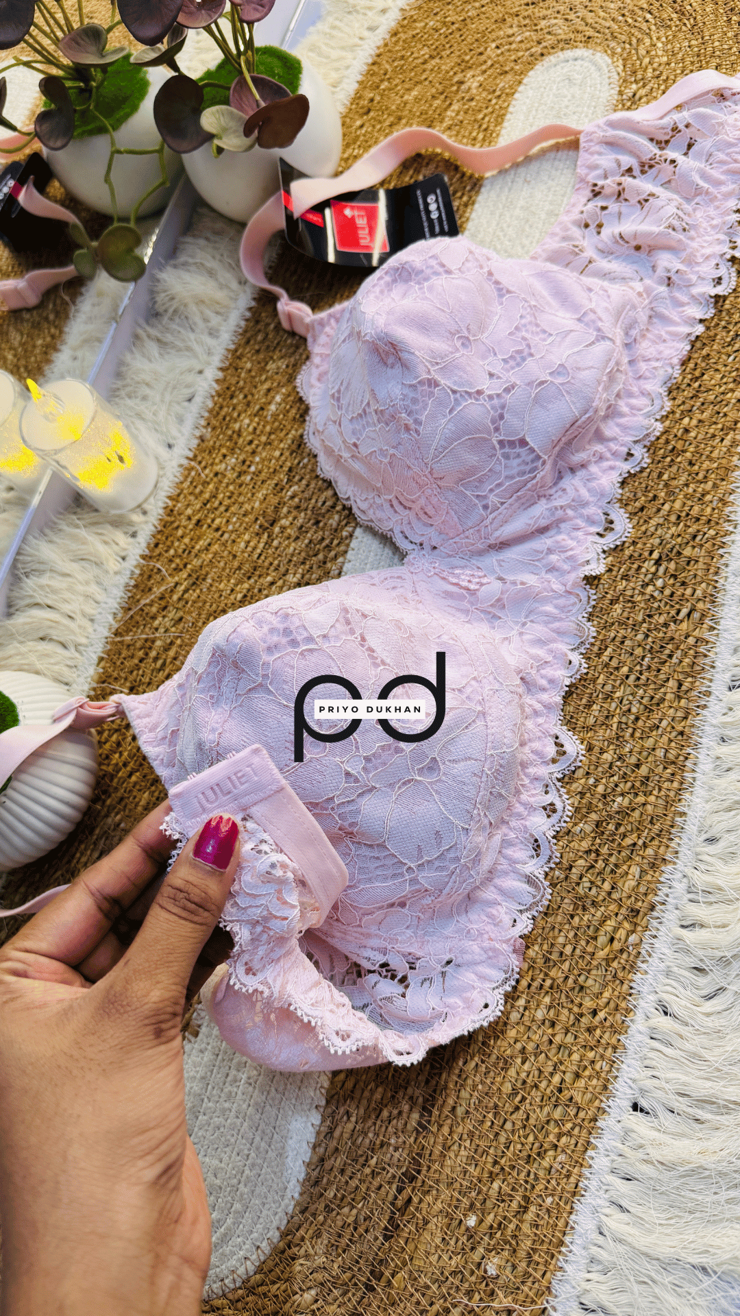 Pink bra with lace details on a textured surface, brand 'pd' visible
