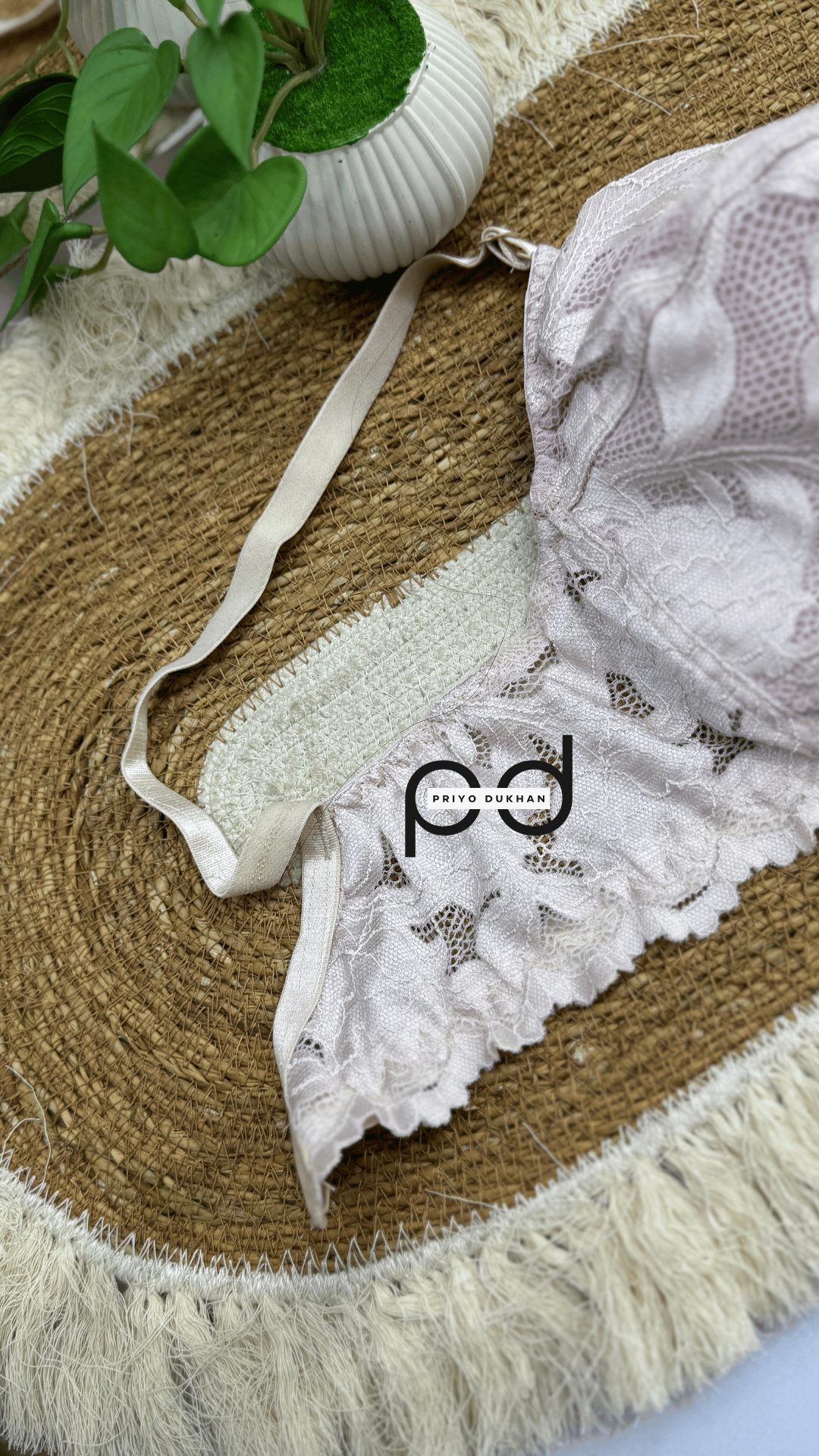 White lace lingerie on a textured surface with a brand logo.